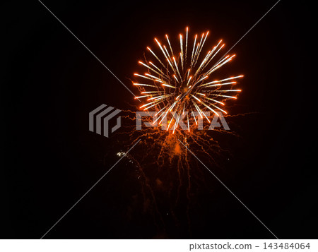 Golden orange fireworks exploding in dark night sky Golden orange fireworks exploding in dark night sky 143484064