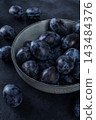Fresh plums in a clay bowl. 143484376