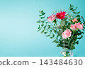 A bouquet of pink and red flowers against a light blue background. 143484630
