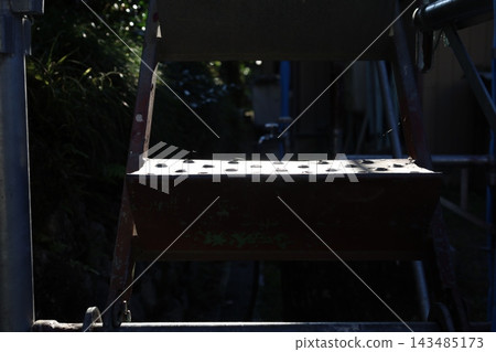 建築工地金屬鷹架板的特寫:穿孔鋼板形成強烈的對比。 建築工地金屬鷹架板的特寫:穿孔鋼板形成強烈的對比。 143485173
