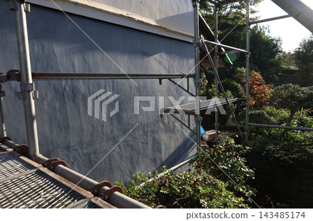 一處翻修工地,建築物外牆被防護布和鷹架覆蓋,展現出秋日美景。 一處翻修工地,建築物外牆被防護布和鷹架覆蓋,展現出秋日美景。 143485174