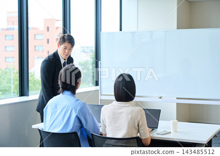 年輕男女在辦公室接受講師關於財富累積和投資的講解。 年輕男女在辦公室接受講師關於財富累積和投資的講解。 143485512