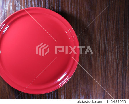 A red plate and a wooden table A red plate and a wooden table 143485953