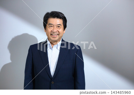 A man in his 60s wearing a suit A man in his 60s wearing a suit 143485960