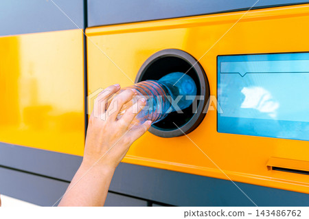 Plastic bottle inserted into reverse vending machine. Plastic bottle inserted into reverse vending machine. 143486762