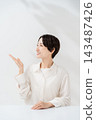 A smiling woman extends her hand to guide you. 143487426
