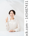 A woman smiling with a thumb 143487431