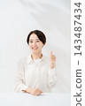 A woman smiling with a thumb 143487434