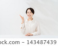 A smiling woman explains while holding up her index finger. 143487439