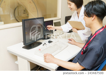 一位日本女醫生和一位男性CT技師正在查看CT掃描影像。 一位日本女醫生和一位男性CT技師正在查看CT掃描影像。 143487500