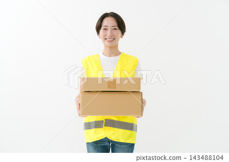 Female delivery person holding a cardboard box Female delivery person holding a cardboard box 143488104