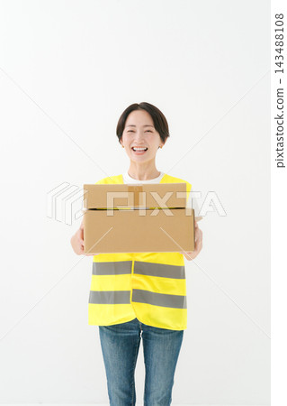 Female delivery person holding a cardboard box Female delivery person holding a cardboard box 143488108
