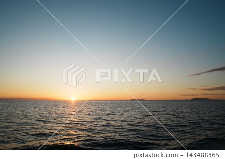 夕陽西下,落日餘暉灑在地平線下,湛藍的天空映襯著一座島嶼的輪廓。 夕陽西下,落日餘暉灑在地平線下,湛藍的天空映襯著一座島嶼的輪廓。 143488365