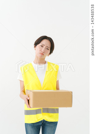 The delivery woman has a thoughtful expression on her face. The delivery woman has a thoughtful expression on her face. 143488538