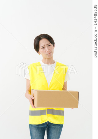 The delivery woman has a thoughtful expression on her face. The delivery woman has a thoughtful expression on her face. 143488539