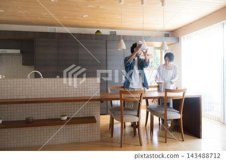 一對日本夫婦在家中餐廳一起打掃和做家務;雙薪家庭的家務分工與分擔(全身廣角鏡頭) 一對日本夫婦在家中餐廳一起打掃和做家務;雙薪家庭的家務分工與分擔(全身廣角鏡頭) 143488712