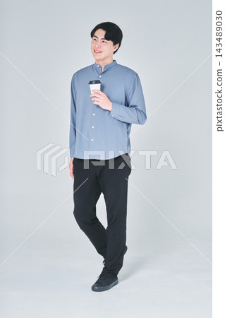一個男人手裡拿著一杯咖啡 一個男人手裡拿著一杯咖啡 143489030