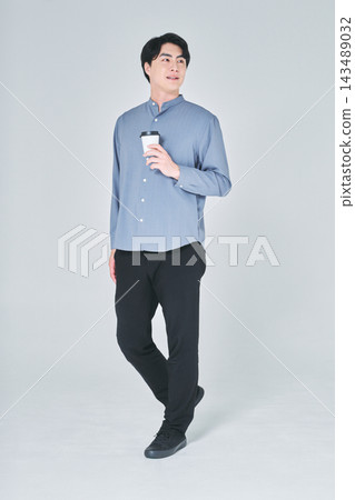 一個男人手裡拿著一杯咖啡 一個男人手裡拿著一杯咖啡 143489032