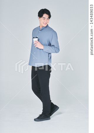 一個男人手裡拿著一杯咖啡 一個男人手裡拿著一杯咖啡 143489033