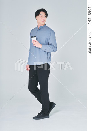 一個男人手裡拿著一杯咖啡 一個男人手裡拿著一杯咖啡 143489034