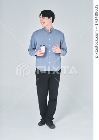 一個男人手裡拿著一杯咖啡 一個男人手裡拿著一杯咖啡 143489035