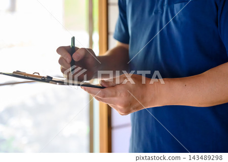 一名工人正在填寫活頁夾。 一名工人正在填寫活頁夾。 143489298