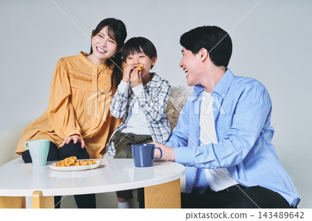 一家人坐在沙發上 一家人坐在沙發上 143489642
