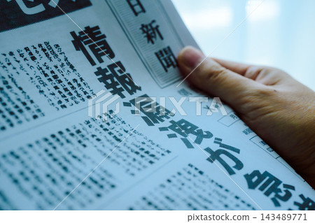 一個人正在閱讀一份刊登了資料外洩新聞的報紙。 一個人正在閱讀一份刊登了資料外洩新聞的報紙。 143489771