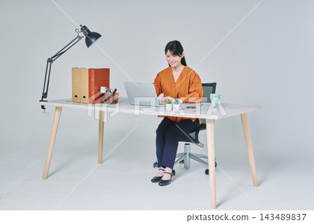 工作在書桌的一名婦女 工作在書桌的一名婦女 143489837