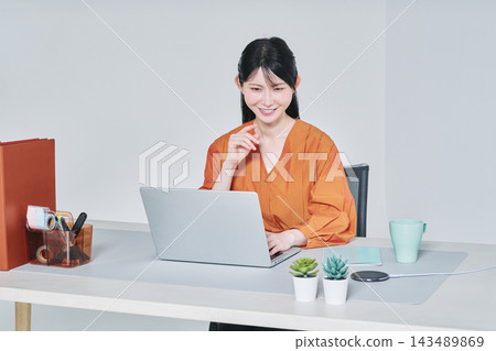 A woman working at a desk 143489869