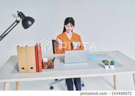 工作在書桌的一名婦女 工作在書桌的一名婦女 143489872