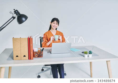 工作在書桌的一名婦女 工作在書桌的一名婦女 143489874