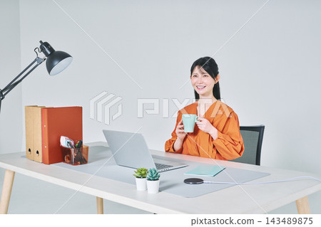 工作在書桌的一名婦女 工作在書桌的一名婦女 143489875