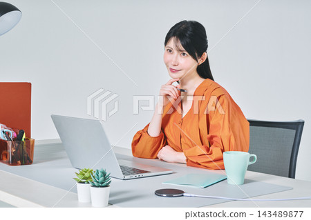 工作在書桌的一名婦女 工作在書桌的一名婦女 143489877