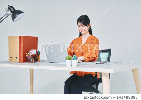 工作在書桌的一名婦女 工作在書桌的一名婦女 143489883
