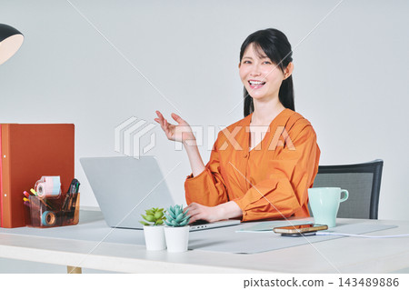 工作在書桌的一名婦女 工作在書桌的一名婦女 143489886