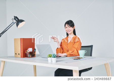 工作在書桌的一名婦女 工作在書桌的一名婦女 143489887