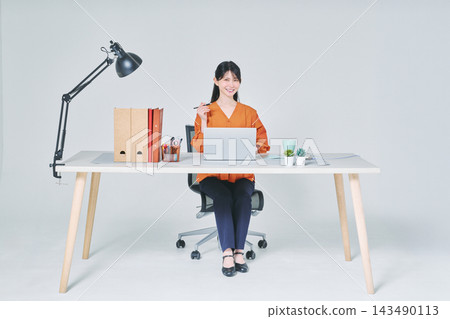 工作在書桌的一名婦女 工作在書桌的一名婦女 143490113