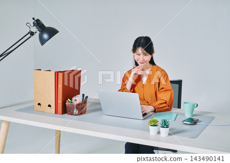 工作在書桌的一名婦女 工作在書桌的一名婦女 143490141