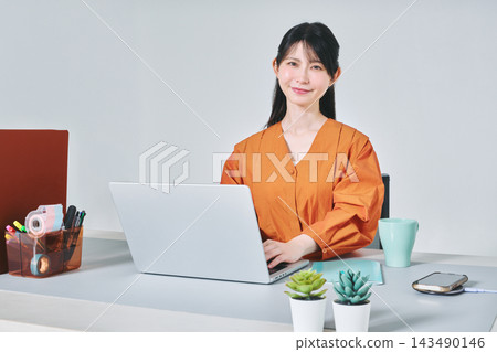 工作在書桌的一名婦女 工作在書桌的一名婦女 143490146