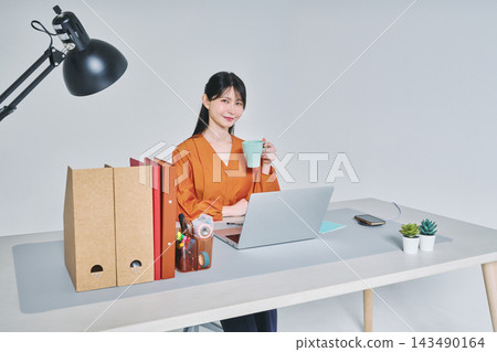 工作在書桌的一名婦女 工作在書桌的一名婦女 143490164