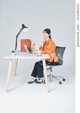 工作在書桌的一名婦女 工作在書桌的一名婦女 143490203