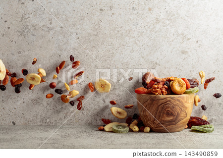 Mix of dried fruits and nuts on a gray stone table. 143490859