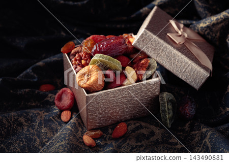 Dried tropical fruits, nuts, and raisins in gift box. Dried tropical fruits, nuts, and raisins in gift box. 143490881