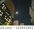 The moon seen between buildings 143491893