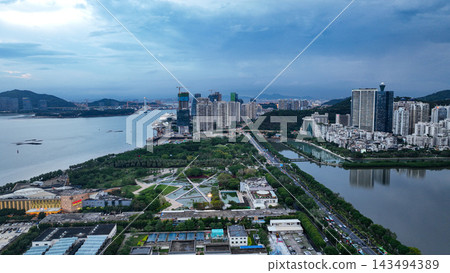 廈門海濱長廊日落時的空拍照片,展現了城市燈光和海灣景色。 廈門海濱長廊日落時的空拍照片,展現了城市燈光和海灣景色。 143494389