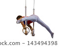 Male gymnast performing routine on still rings 143494398