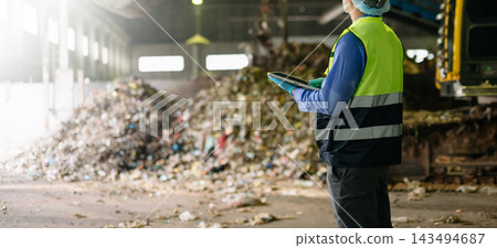 Quality inspector in hardhat and mask taking notes beside a large compost pile, evaluating organic waste management Quality inspector in hardhat and mask taking notes beside a large compost pile, evaluating organic waste management 143494687