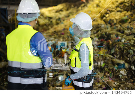 Engineers analyze smart waste management and green energy data overlays at a recycling facility. Engineers analyze smart waste management and green energy data overlays at a recycling facility. 143494795