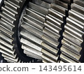Detailed view of metal gears showing teeth and texture in a mechanical setting at a manufacturing plant 143495614
